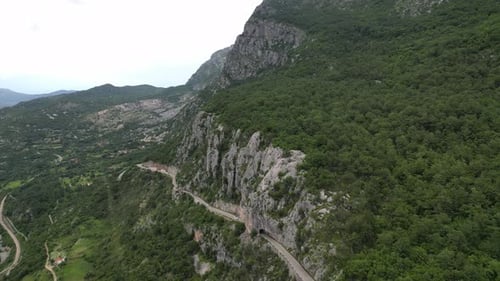 Beautiful mountain road passing along the big green mountains. Aerial view. Montenegro.