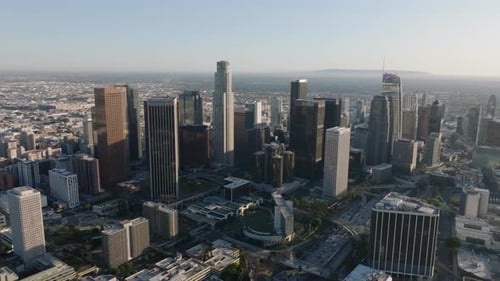 Aerial Cinematic Footage of Modern High Rise Downtown Buildings Towering Above Surrounding Town