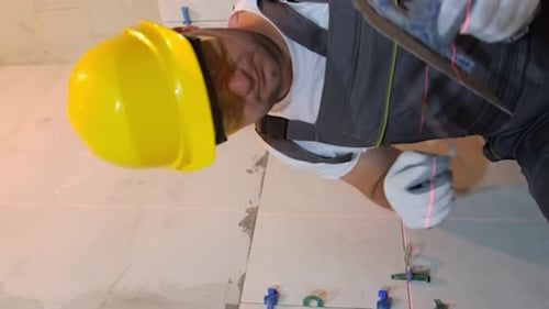 Man in Safety Gear Wearing a Helmet Working on a Wall