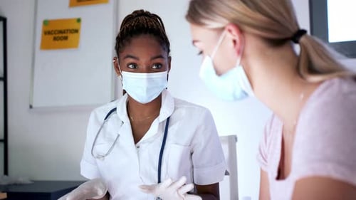 Woman receiving vaccine from medical professional in clinic