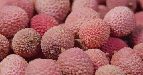 Rotationshintergrund mit exotischen Früchten aus Litschi. Geerntete Litschifrüchte oder Beeren. Asiatisches Essen