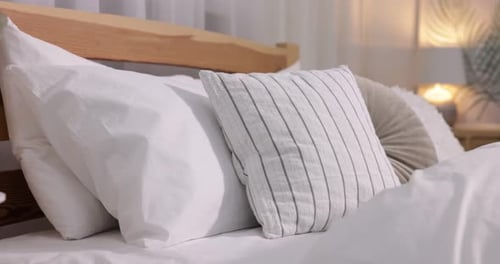 Comfortable bed with fresh cotton linens indoors, closeup