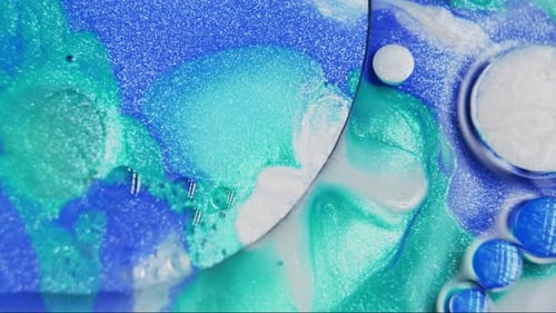 Blue and turquoise inks swirling in water creating abstract art