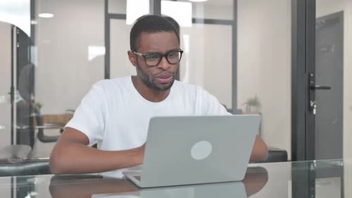 Young African Man Doing Video Chat in Office