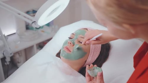 Young Woman on Beauty Procedure Clue Face Mask in Cosmetology Clinic