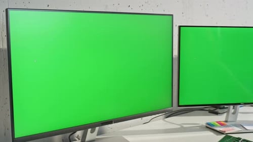 Two Chroma Key Displays Standing at Office Table Zoom Out Retoucher Working