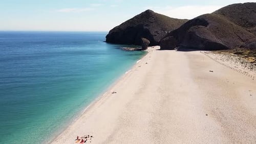 Drone aerial view of seashore, coastline, scenic view of people at unspoiled beach