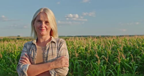Female Farmer Smiling in a Cornfield on Sunny Day