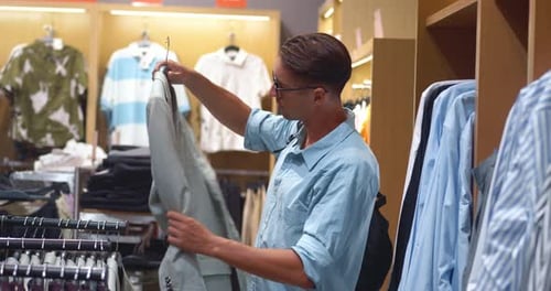 Man Inspecting Blazer in Clothing Store