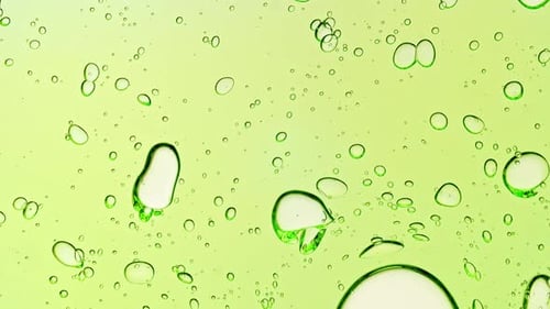 Transparent Green Cosmetic Gel Fluid With Molecule Bubbles and Oil on White Background