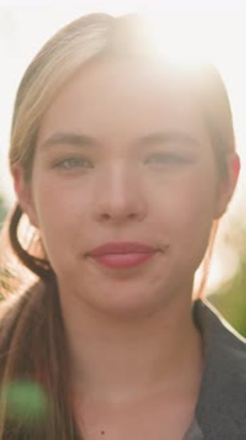 Gros plan d'une femme souriante au soleil avec une lumière naturelle douce