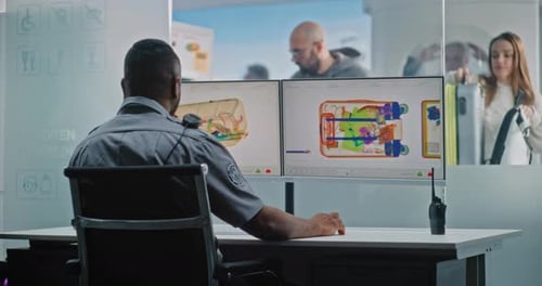 Airport Security Agent Inspecting Luggage X-rays