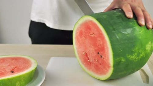 Mann schneidet Wassermelonenscheiben, um ein süßes Dessert zu essen