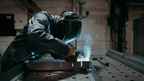 Arbeiter in Industrieuniform und geschweißter Eisenmaske in Stahlfabriken: Erster Arbeitsschutz