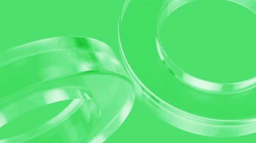 Rotating glass rings on green background