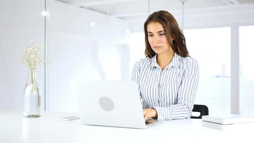 Serious Woman Busy Working On Laptop in Office