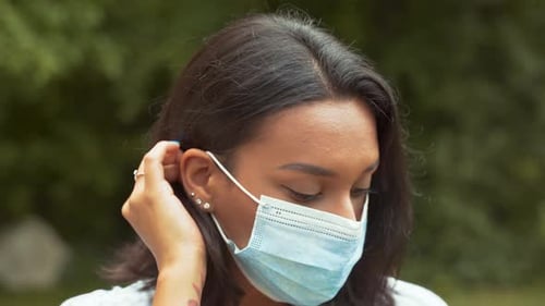 Portrait of a Beautiful Dark Haired Young Woman Taking Off Protective Medical Face Mask Then Smile.