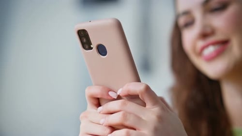 Smiling Woman Using Smartphone Indoors
