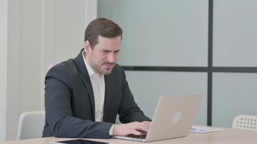Businessman Reacting to Loss While Working in Office