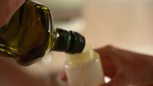 Refilling oil-cruet. Close up and slow motion