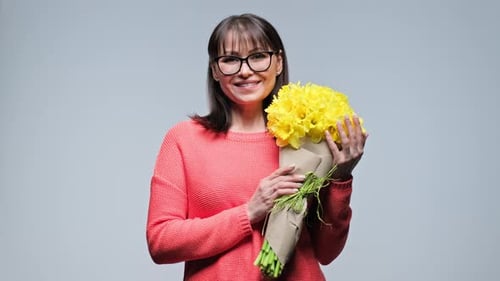 Smiling Woman Holding Bouquet of Yellow Spring Flowers