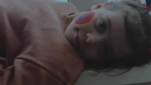 Cheerful Little Girl with Telephone and Satellite Dish Symbol Paintings on Her Face Communication