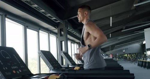 Atleta focado correndo em uma esteira em uma academia moderna