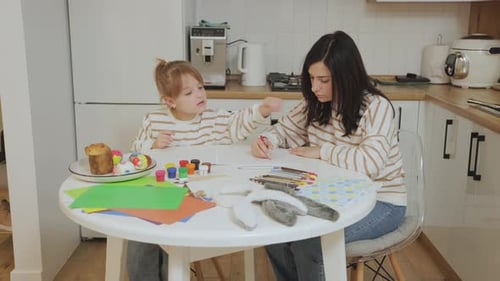 Mother and Child Drawing Easter Decorations at Home