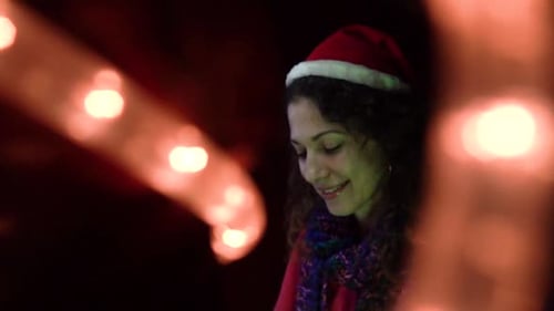 Woman Smiling Wearing a Santa Hat With Lights