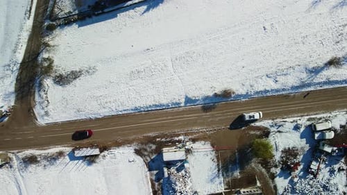 Aerial view of a van driving on a rural road with snowy landscape on a sunny winter day, Dalmatia, C