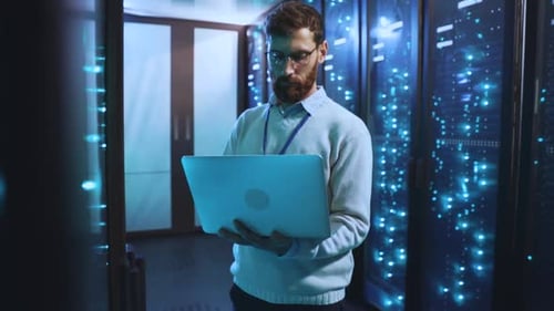 Man With Laptop Stands In Server Room