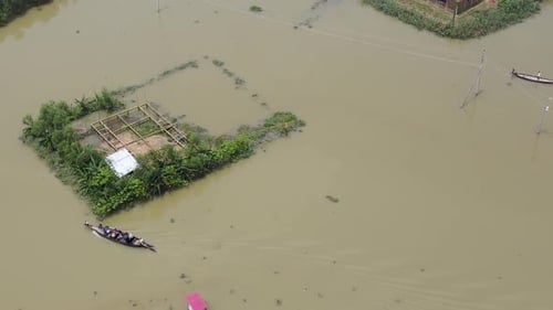 Drone pans over flood zone, boats evacuate near submerged buildings