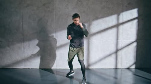 Tired Athlete Training Boxing Punching Air in Loft Gym Man Cardio Exercising