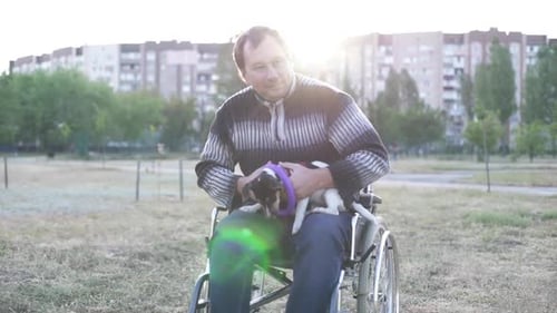 Man in Wheelchair Holding Puppy with Dog Toy