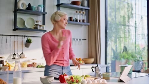 Happy Woman Cooking and Dancing in Kitchen
