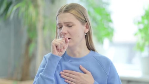 Young Woman Coughs Indoors, Health and Wellness