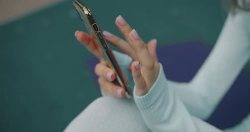 Closeup of Female Hands Hold Smartphone Typing and Send Message After Workout