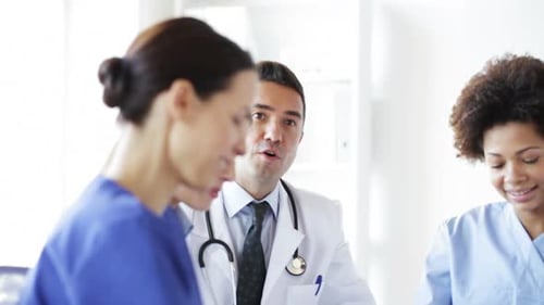 Happy doctors and nurses meeting at medical seminar in the hospital looking at presentation