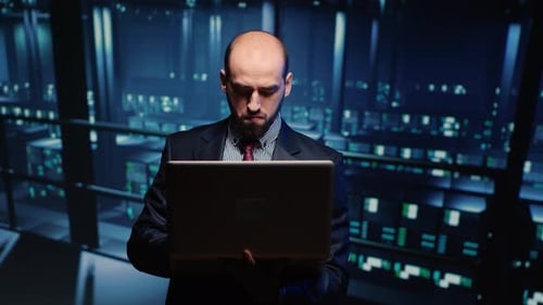 Man Using Laptop in Futuristic Server Room