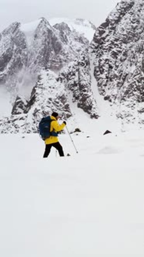 Hiker Walking on Colorful Rocks with Snowy Mountain in the Background