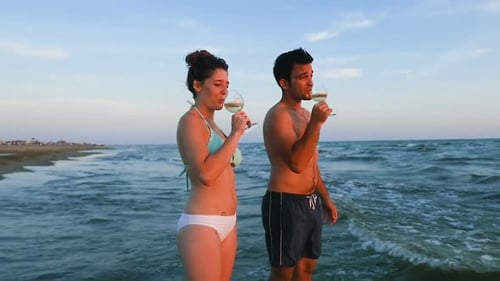 Romantic Couple Toasting with Wine at Sunset Beach