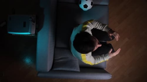Frustrated Man Watches Soccer on Projector at Home