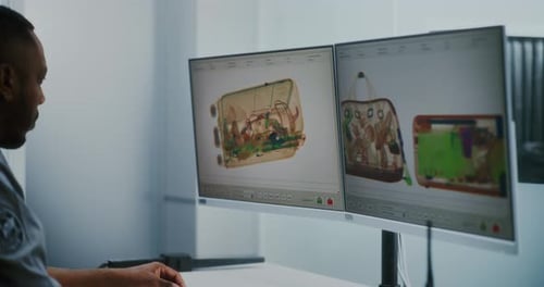 Security Worker Watches X-Ray Monitor