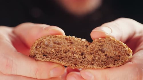Close-up of Hands Holding Delicious Fresh Bread Slice