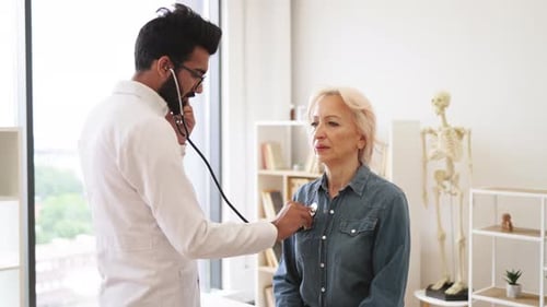 Doctor Listens to Patient's Heart with Stethoscope