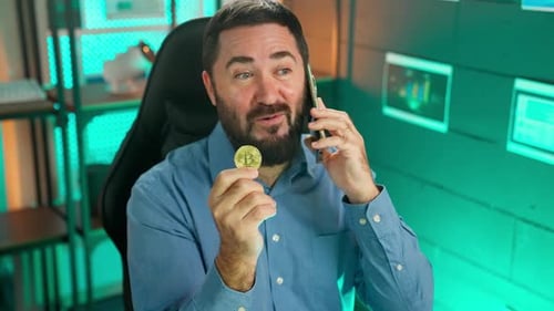Businessman In Office Speaks Phone Coin In Hands