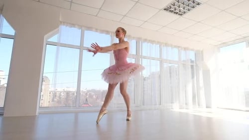 Young Ballerina Dancing in Bright Studio