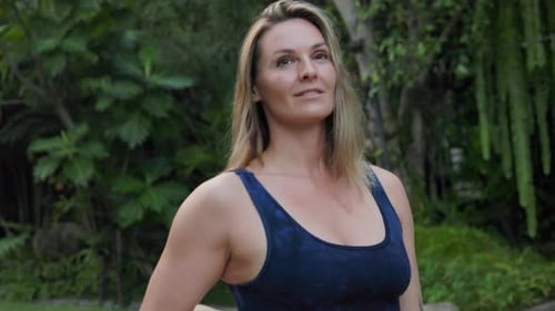 A Woman Carrying a Yoga Mat Through the Park Promotes Wellness and Fitness in the Great Outdoors