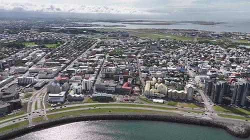 Aerial View of Reykjavik City Center, Iceland, Coastal Traffic, Downtown Buildings and Church, Drone