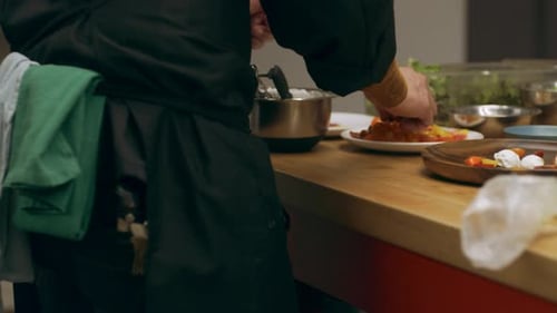 Chef plating appetizer in restaurant kitchen close-up